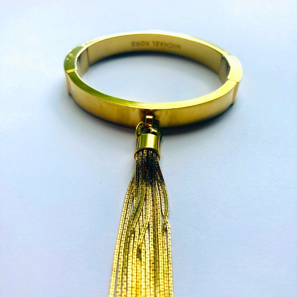 Michael Kors gold bracelet with gold chain tassel.